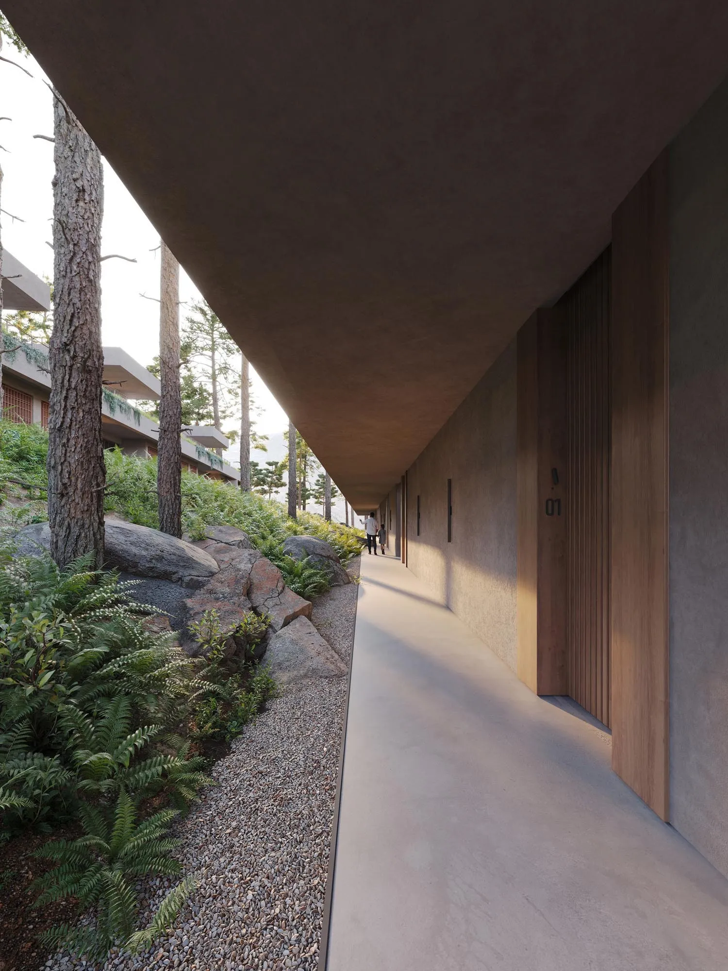Under the cantilevered roof, the corridor with wooden doors