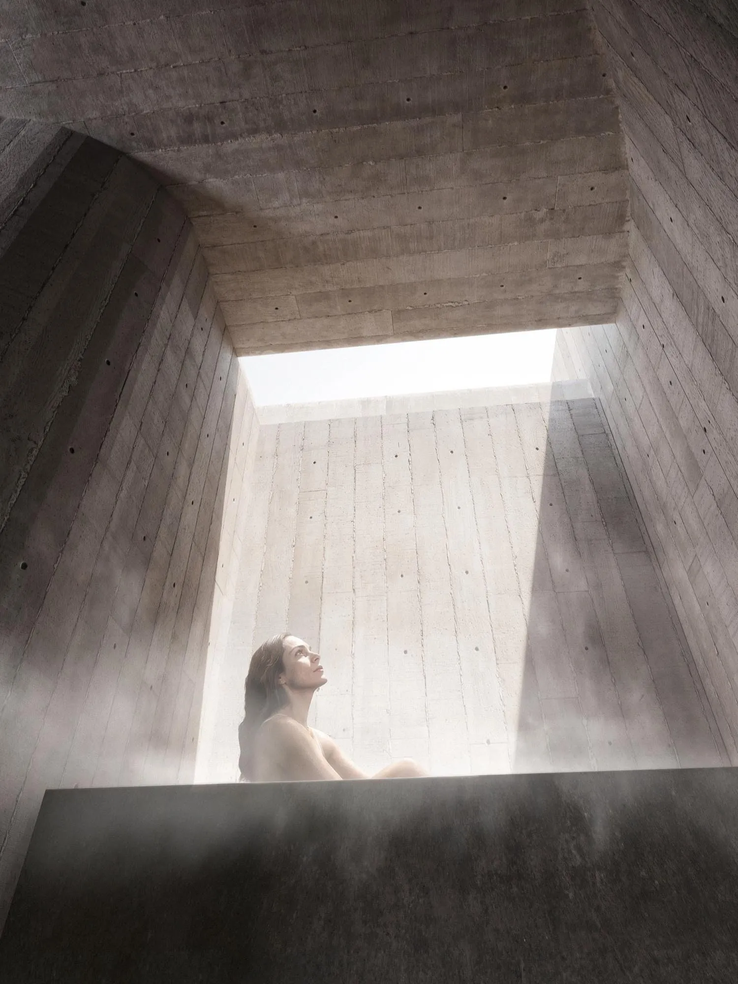 A figure in the shaft of light between concrete walls